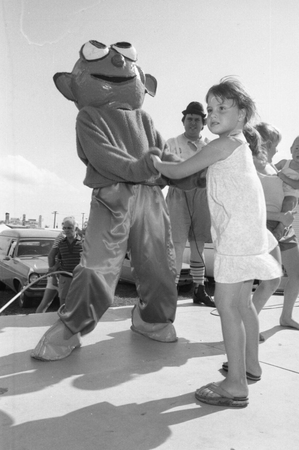Girl dancing with mascot on stage at the Lions Carnival, Ipswich, December 1979