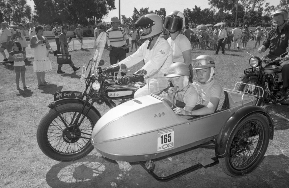 People driving a motorcycle with children in the sidecar at the 1978 Australian International Veteran and Vintage Motor Rally at the Ipswich Showgrounds, Ipswich, April 1978