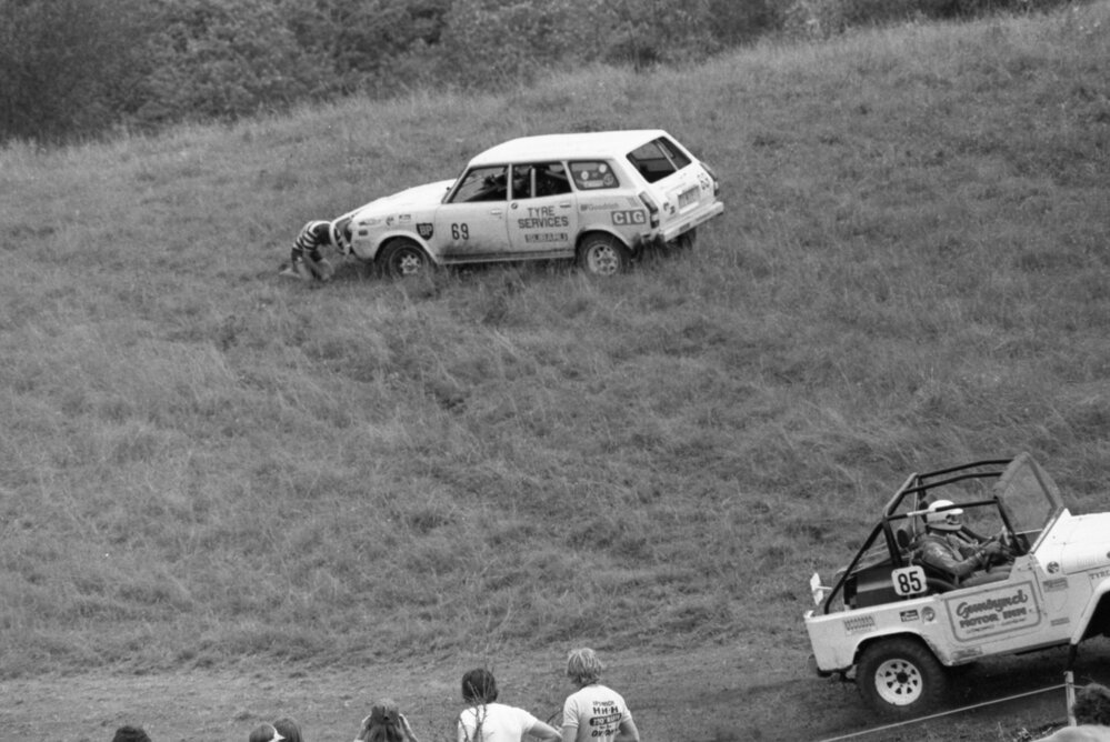 Subaru, No. 69, pulled off the racetrack for tyre replacement while No. 85 and No. 82, driven by Ron Dormar, pass during in the 1979 Queensland Times Off-Road Spectacular, Minden, Somerset, November 1979