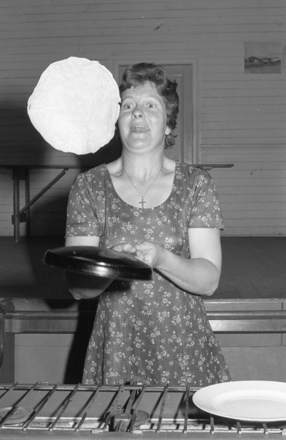 Unidentified woman flipping crepes, Ipswich, October 1977