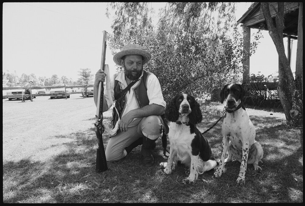 Unidentified man in pioneer costume with dogs, at the Laidley Pioneer Village and Museum, Laidley, 1986 