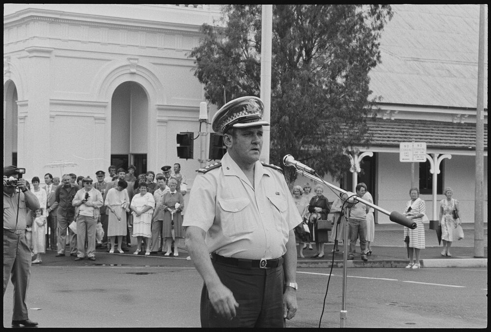 Unidentified Queensland Police officer halting the crew of H.M.A.S. Ipswich as they marched along Brisbane Street, requesting 'Freedom of Entry to the City', Ipswich, January 1986