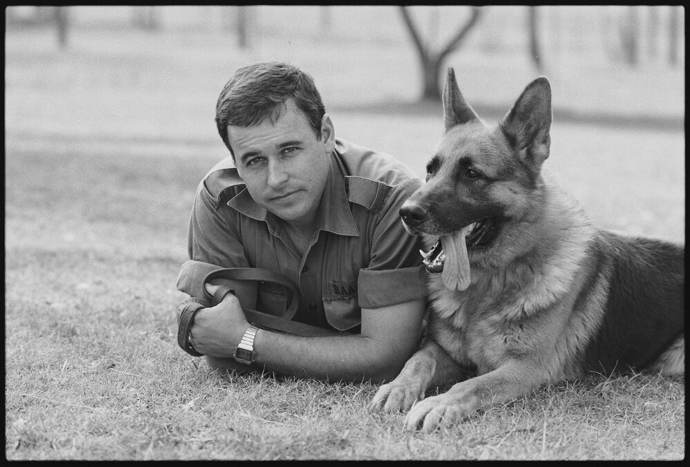 RAAF Serviceman Reynolds relaxing with RAAF Service Dog at RAAF Base Amberley, Amberley, Ipswich, January 1986