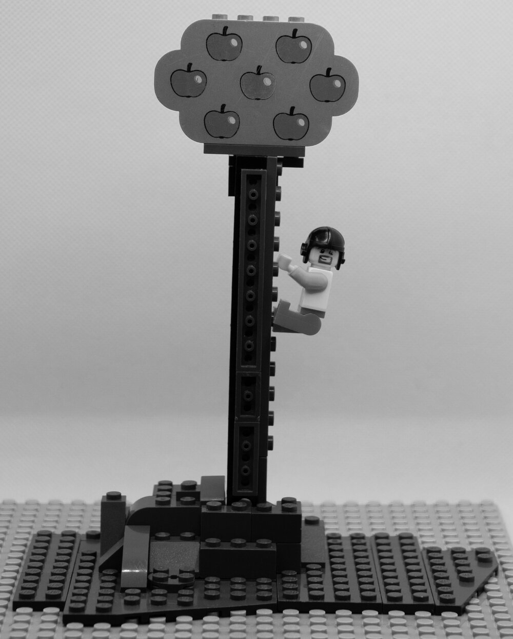 Brickswich version of Allan Saxelby climbing a tree at his home in Booval Street, Booval, from around 1920