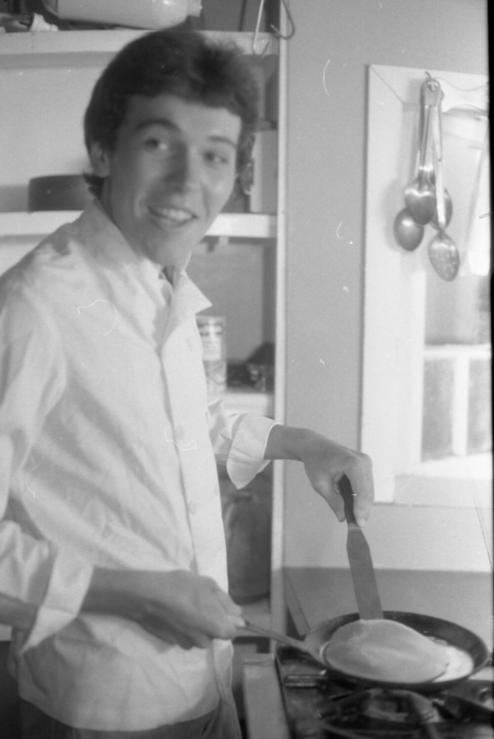 Unidentified man cooking pancakes, Ipswich, February 1985
