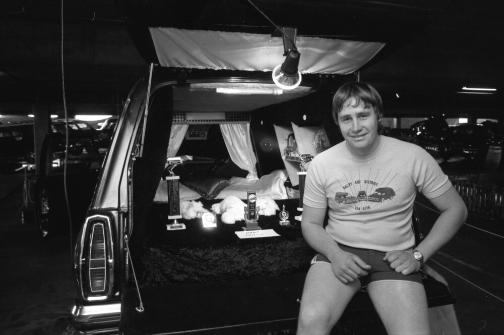 Unidentified man in Dalby and District Van Association shirt with his Holden Sandman van at a Hot Rod Show, Ipswich, August 1980