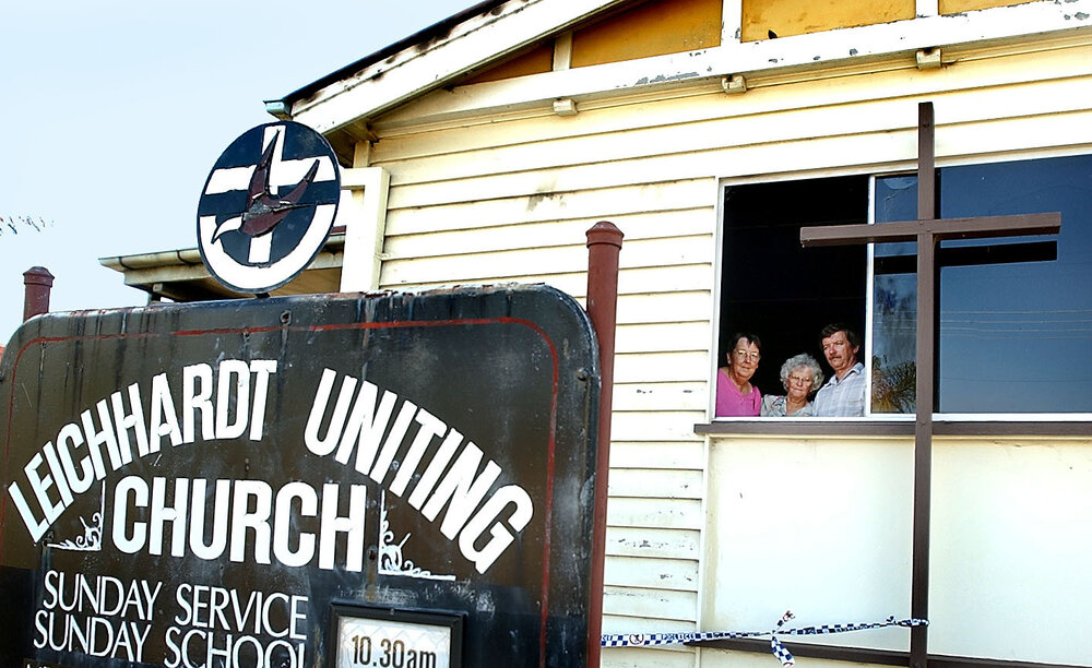 Two unidentified women with Church council secretary, Paul Coker, at Leichardt Uniting Church after church fire, Ipswich, December 2003