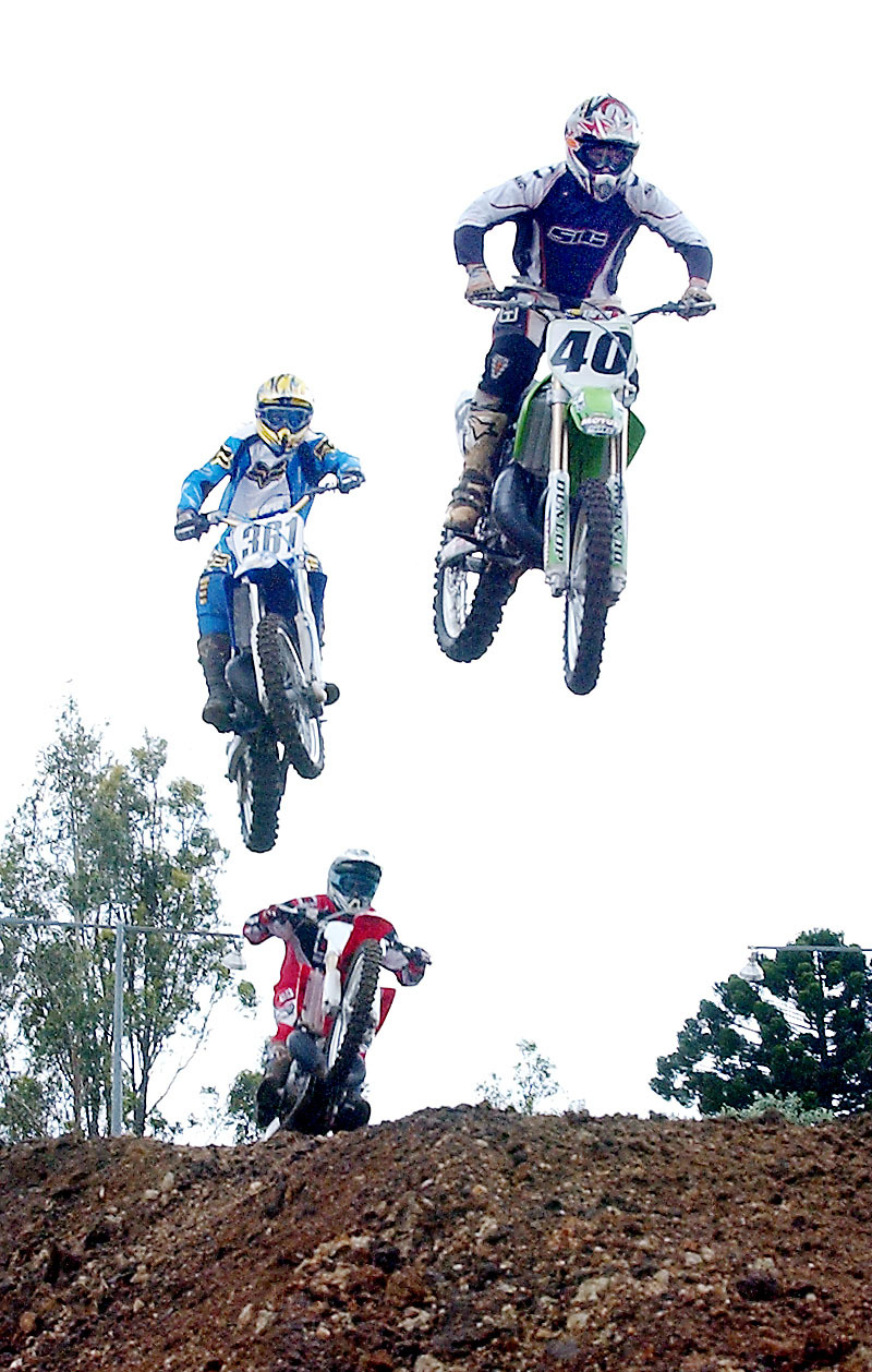 Michael Cook (leading rider) with two unidentified motocross riders, Ipswich, December 2003