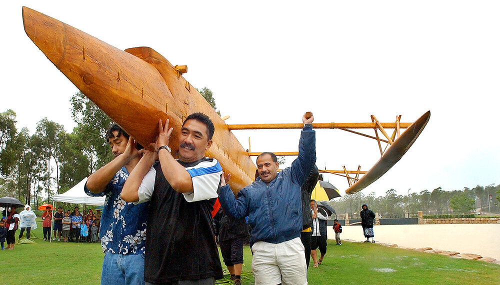 People carrying an outrigger to the lake's edge for launching, Ipswich, December 2003