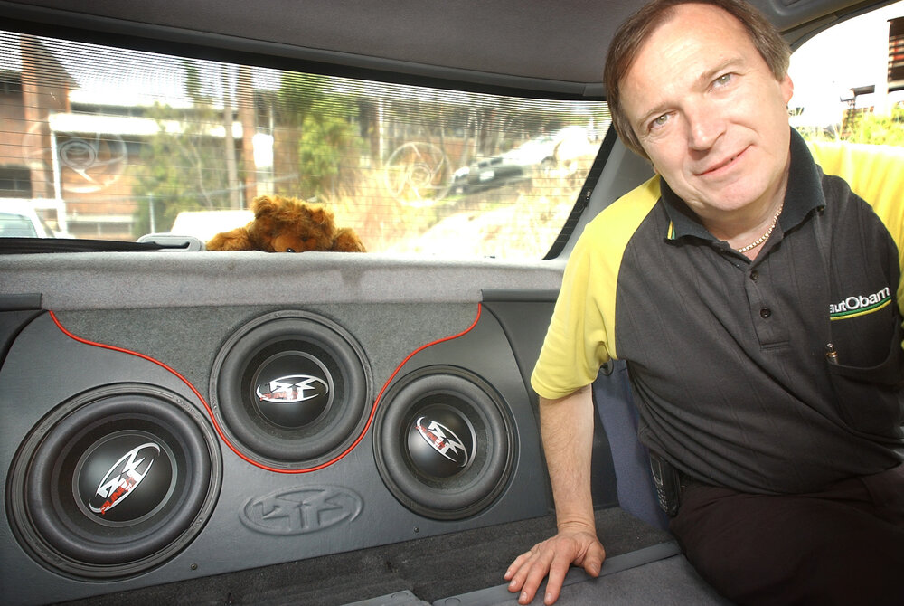 Daryl Neumann of Autobarn Ipswich demonstrating the three, 10-inch Rockford sub-woofers in his car at car show, Rosewood, September 2003