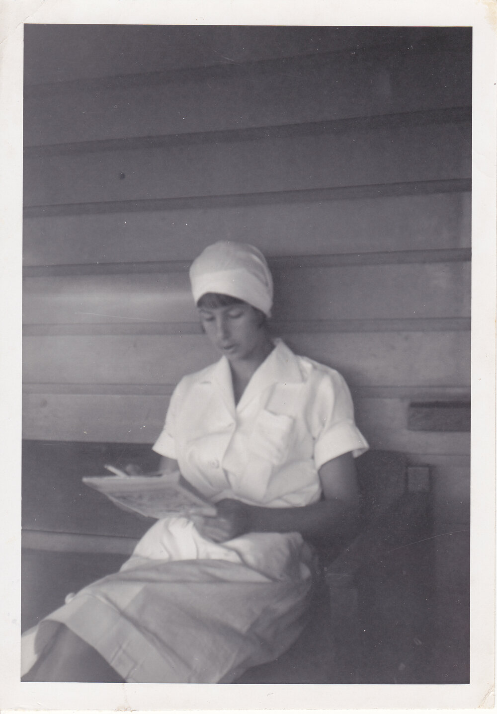 Nurse Judy Kemp reading on bench, Ipswich, 1950s