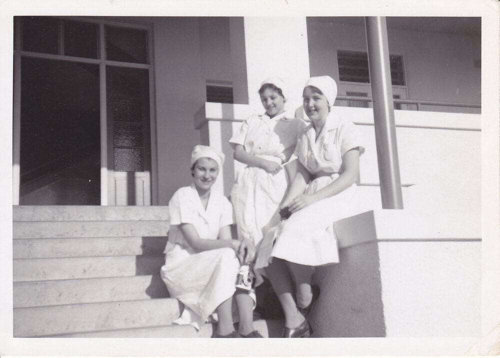 Nurses J. Kerle, Sue Gardiner and Gloria Young sitting on steps of Trumpy House, Ipswich Hospital, 1950s