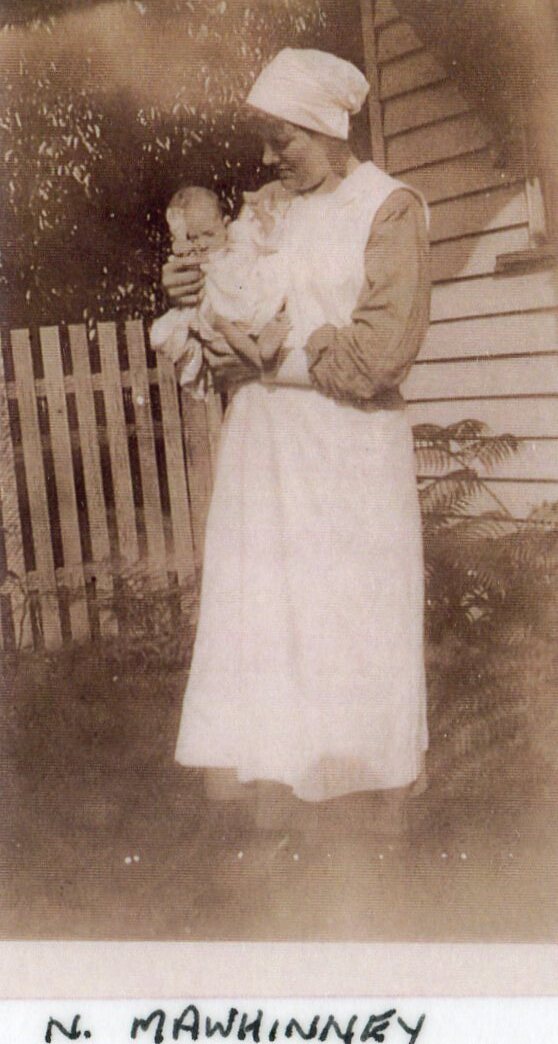 Nurse M A Whinney with baby in grounds, Ipswich General Hospital, c1920