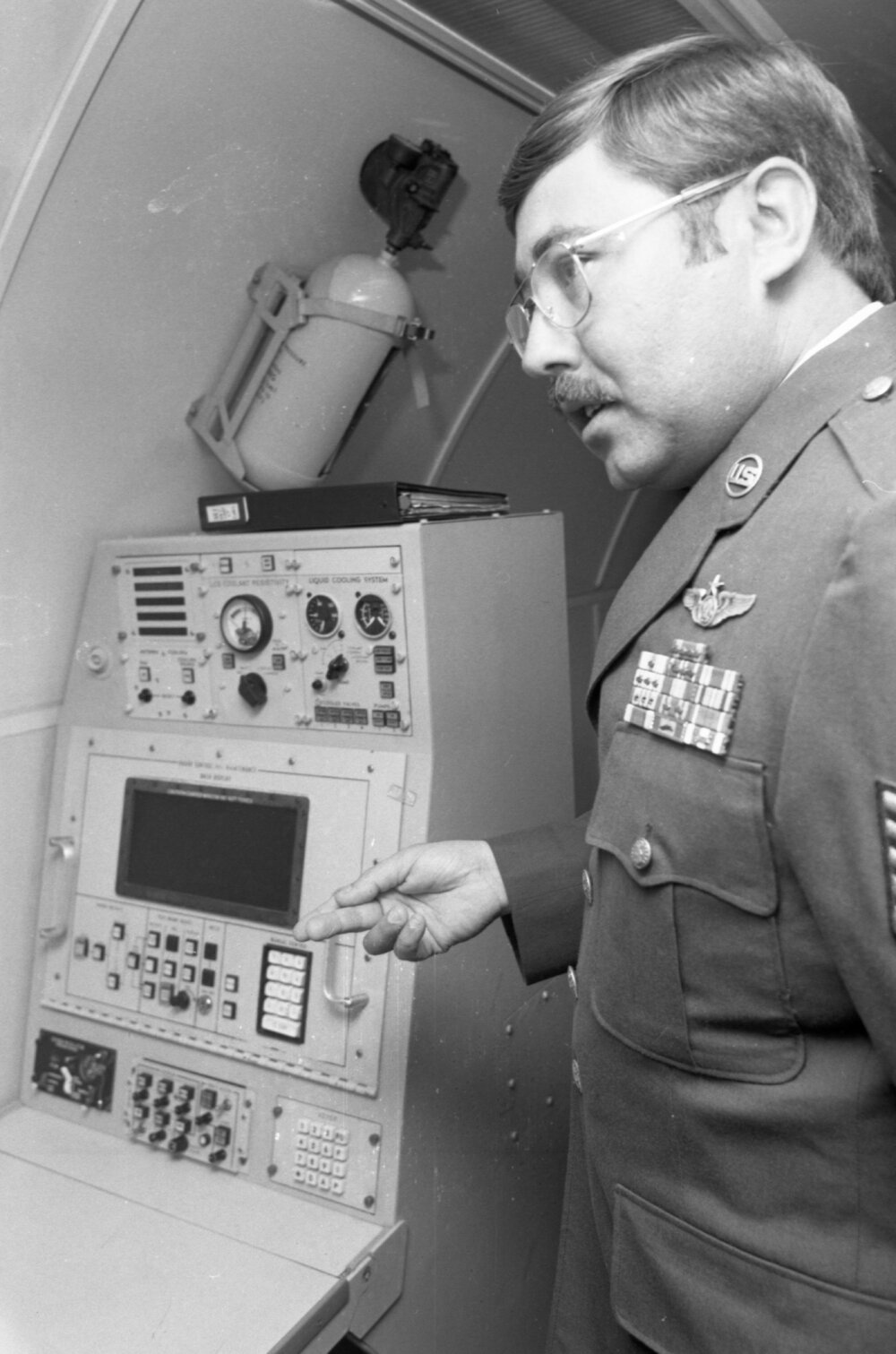 Airman demonstrating a control console in the interior of a RAAF plane, Amberley Air Base, Amberley, Ipswich, September 1980