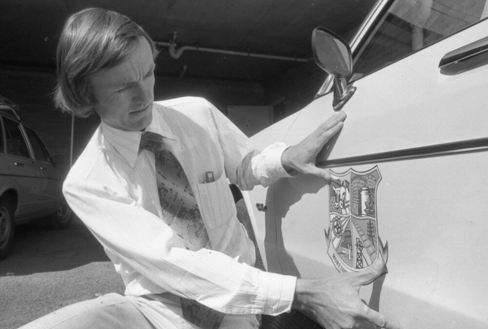 Moreton Shire Councilor Neil William Russell with Moreton Shire Council Crest on a car, Ipswich, September 1980