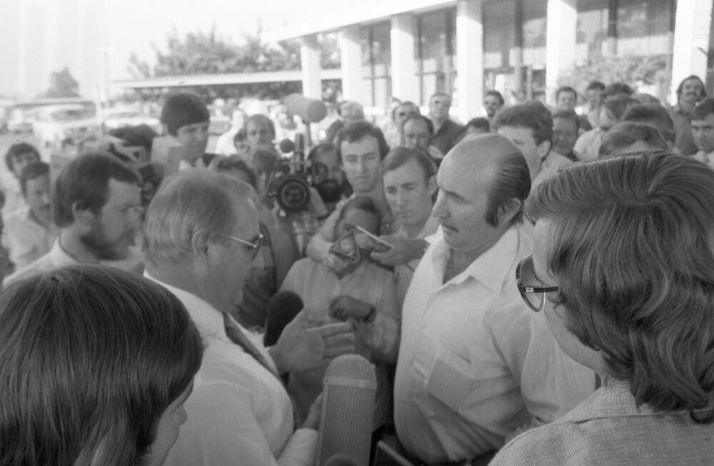 Thought to be Vincent Klein speaking with an unidentified in a crowd at the Shell Roadhouse Meeting, Gailes Ipswich, September 1980