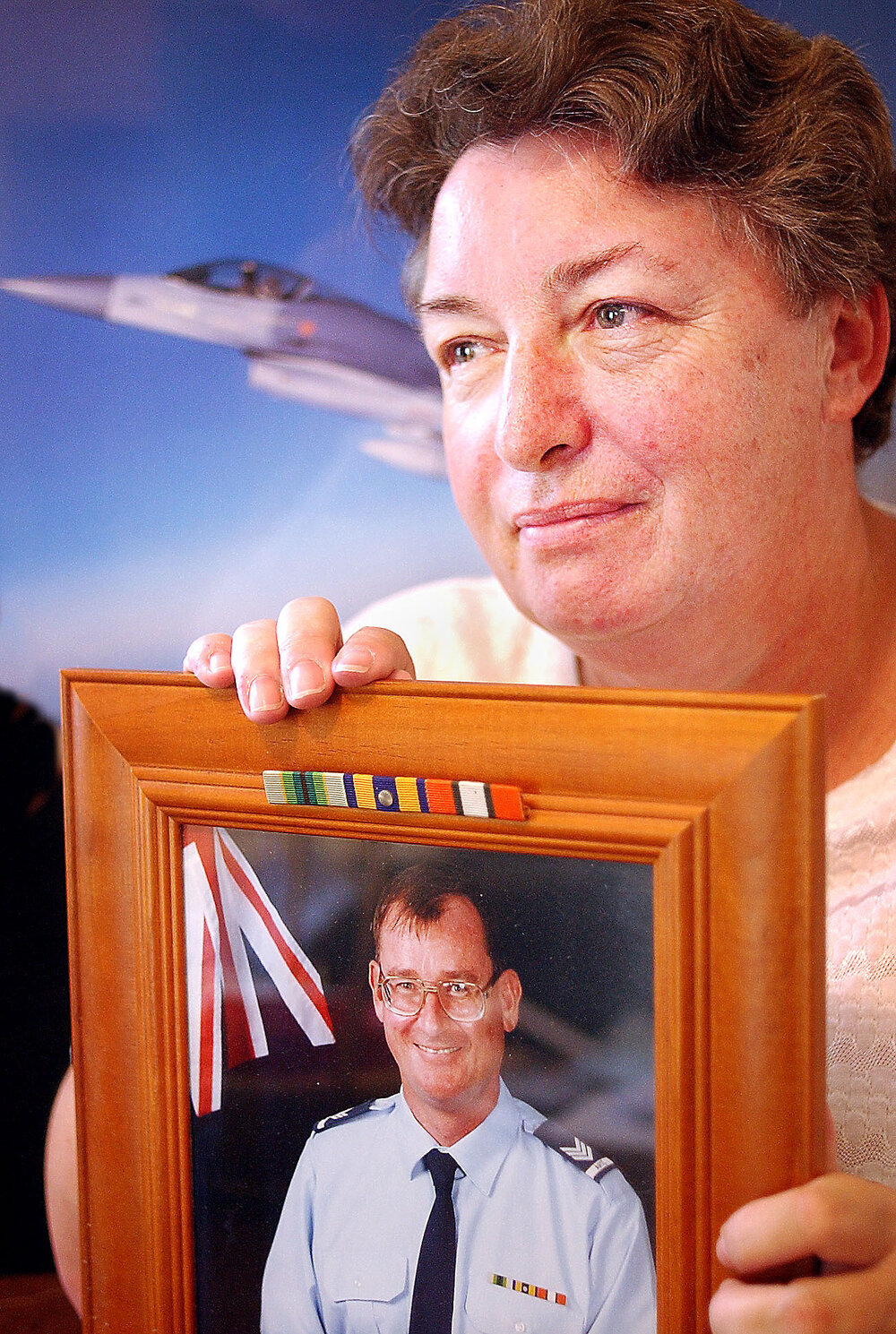 Sue Cross holding an image of an unidentified Royal Australian Air Force Deseal/Reseal, Ipswich, February 2003 