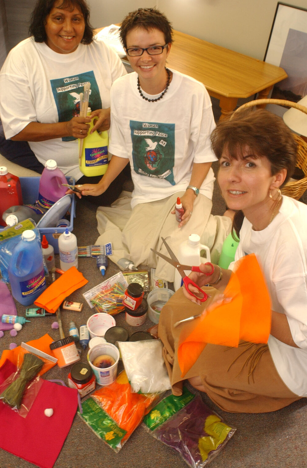 Three unidentified women organising craft supplies for international women's day, Ipswich, March 2003