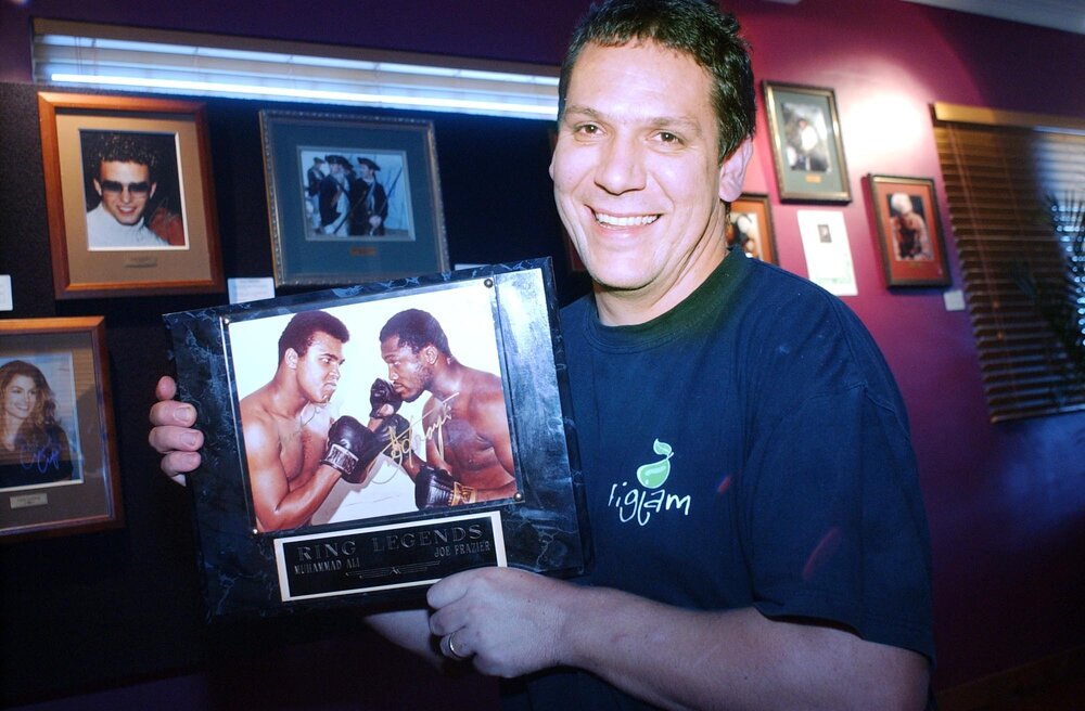 Jason Davidson from Fig Jam Cafe, showing off the cafe's art display, Ipswich, April 2003