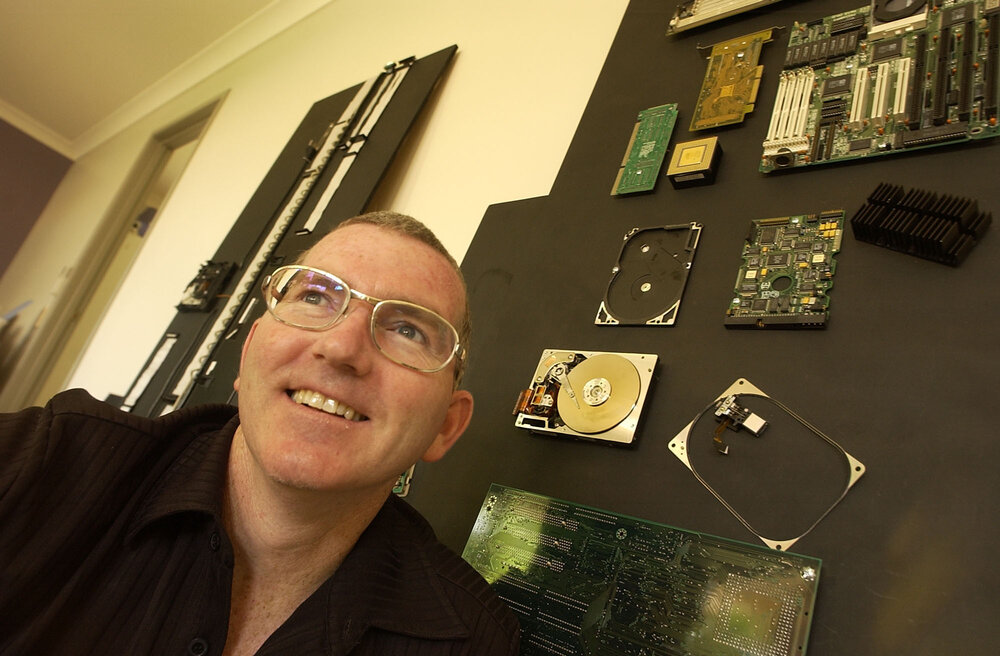 Michael Flynn in front of a wall of motherboards, Ipswich, November 2003