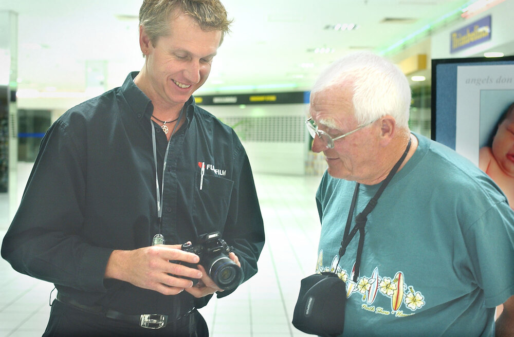 Fuji Sydney (Digital Trainer), Warrewyk Williams shows Ipswich Photographic Society member, Norm Fisher the new Fuji range at an information night at Heritage Photo, Ipswich, November 2003