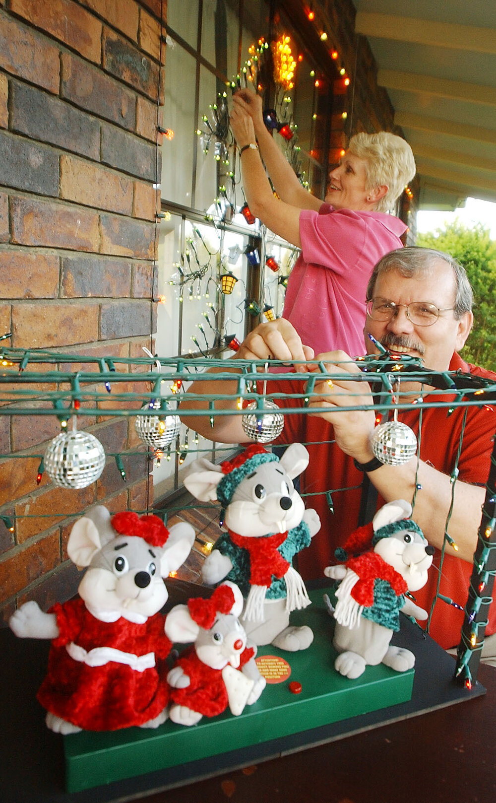 Unidentified man and woman putting up Christmas lights and decorations, Ipswich, November 2003