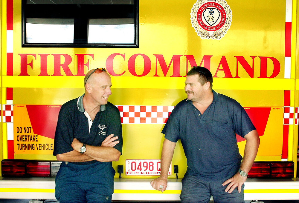 Mark Thompson and Steve Arnold leaning against a fire truck, Ipswich, August 2003