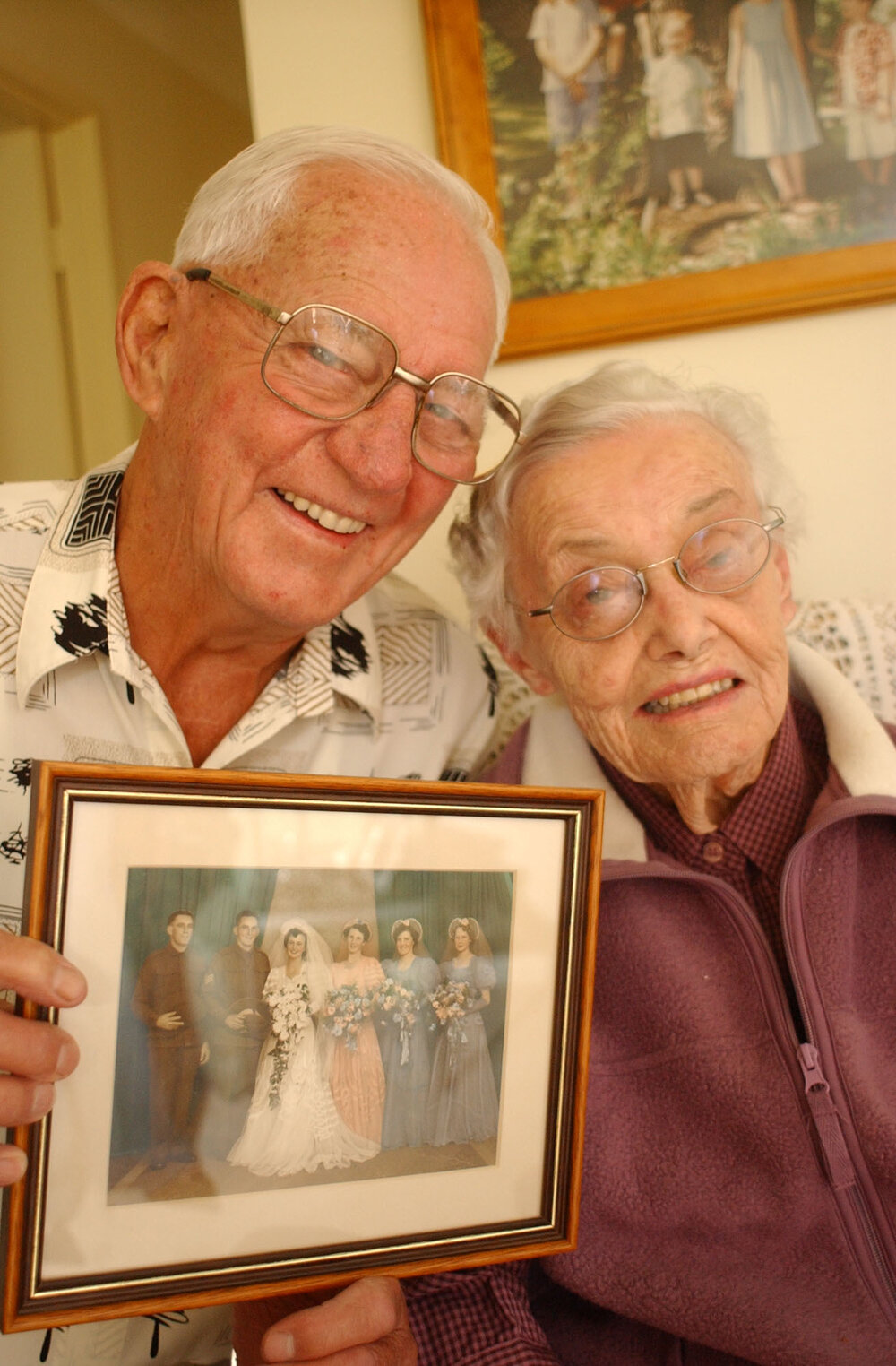 Unidentified married couple holding up a photograph of their wedding, Ipswich, May 2003
