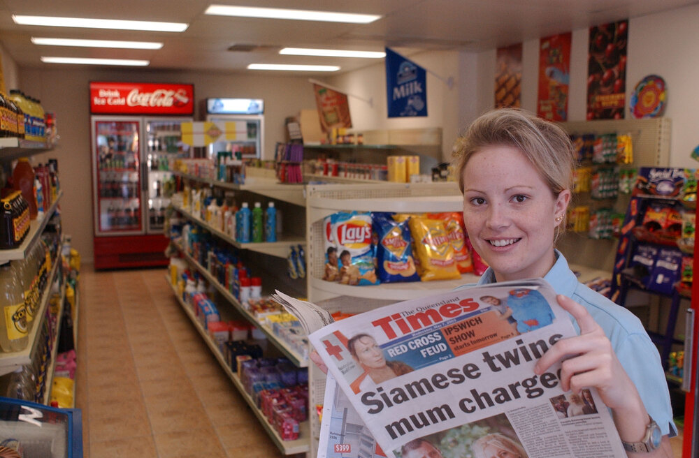 Hayley Pulsford holding a copy of the Queensland Times newspaper at the new  BP Tivoli, Ipswich, May 2003