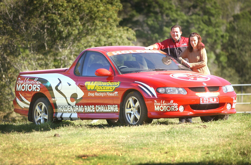Rob Oberg and Belinda Harmer with a car for Holden's Drag Race Challenge, Willowbank, May 2003