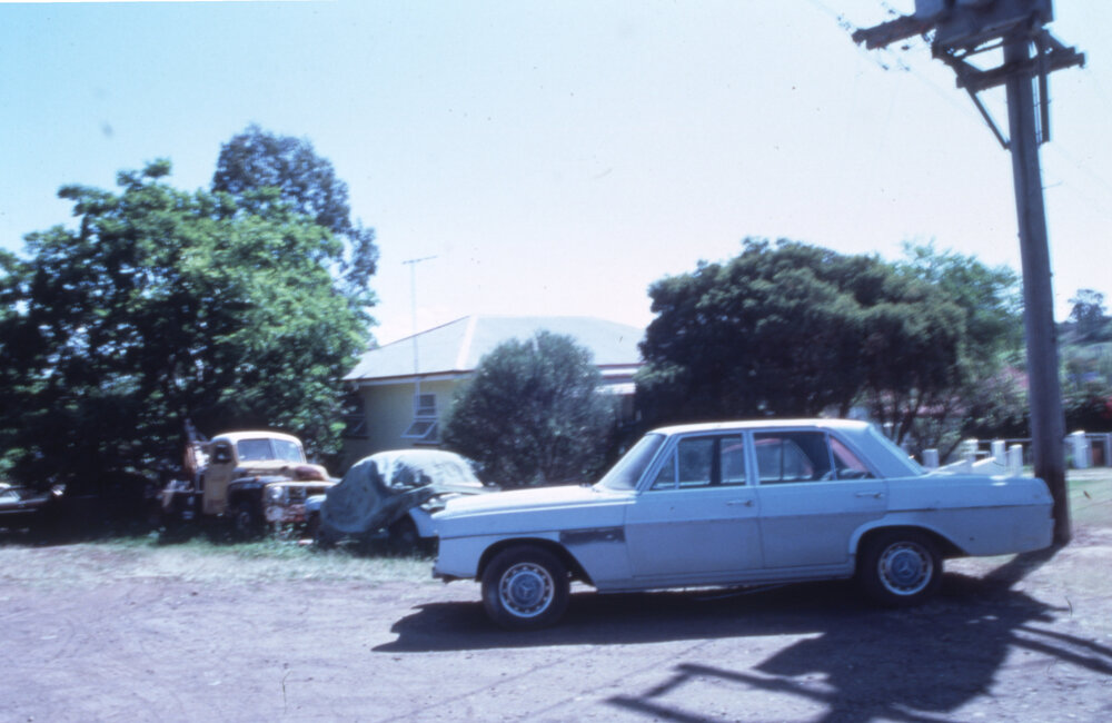 Cars awaiting repairs in a suburban street, location unknown, c.1987