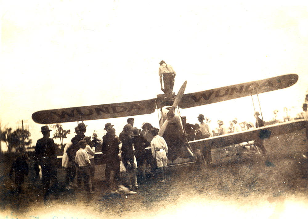 Group inspecting airplane 'Wunda' after it landed near Rosewood, Ipswich, late 1930s