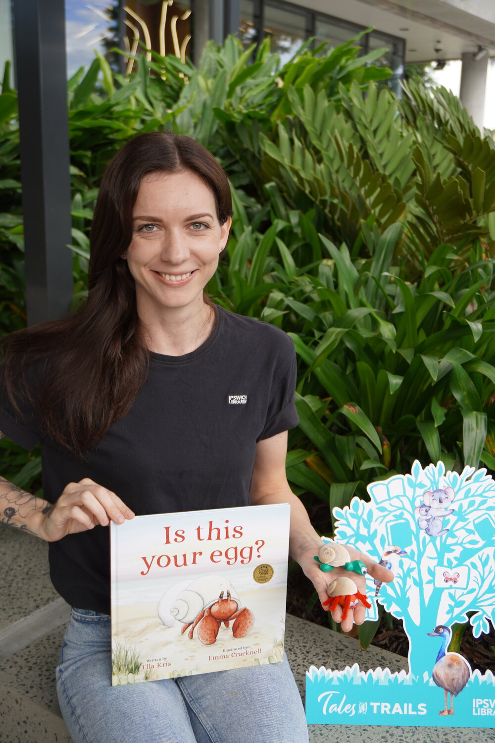 Illustrator Emma Cracknell with her children's book "Is This Your Egg?", written by Ella Kris, outside the Ipswich Children's Library, Tulmur Place, Ipswich, 2022