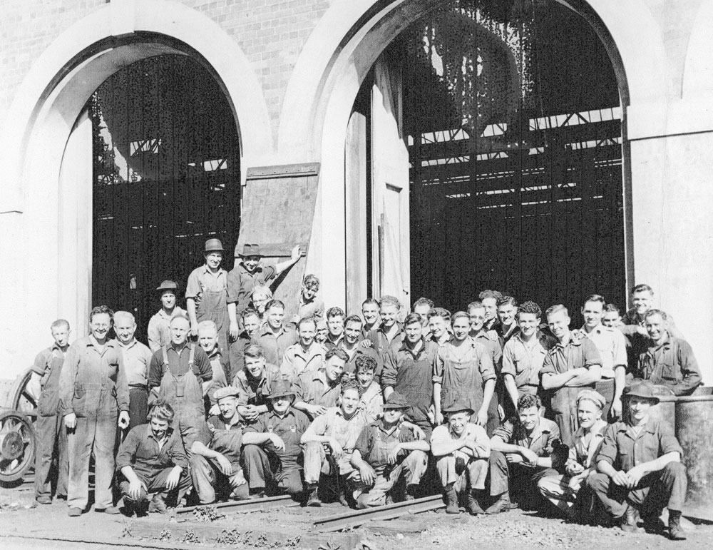 Group of men in front of Erecting shop at Ipswich Railway Workshops, North Ipswich, 1950