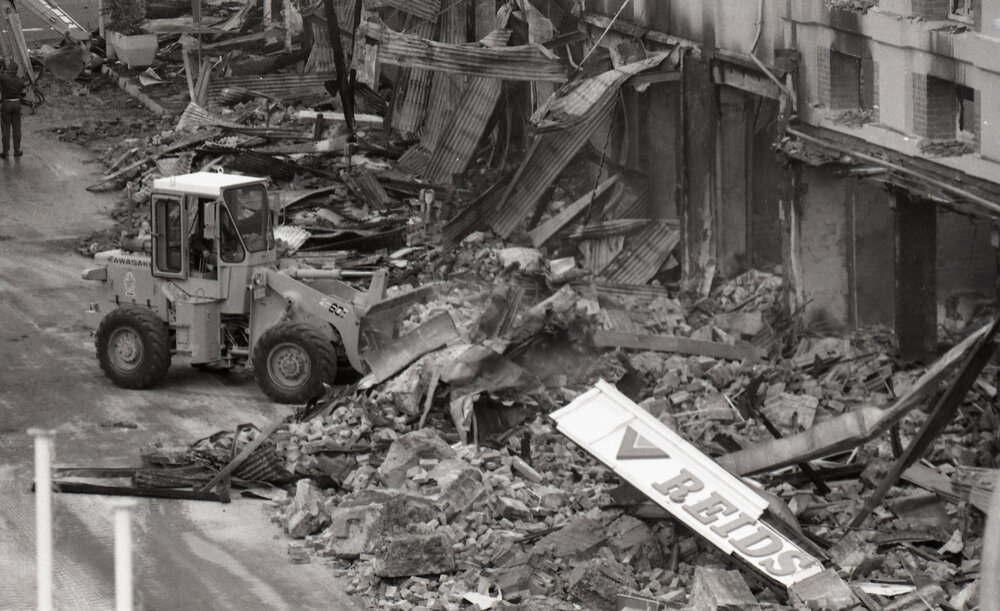 Bulldozer cleaning up the street of rubble, in the aftermath of the Reid's (Cribb &amp; Foote) fire, Bell Street, Ipswich, August 1985