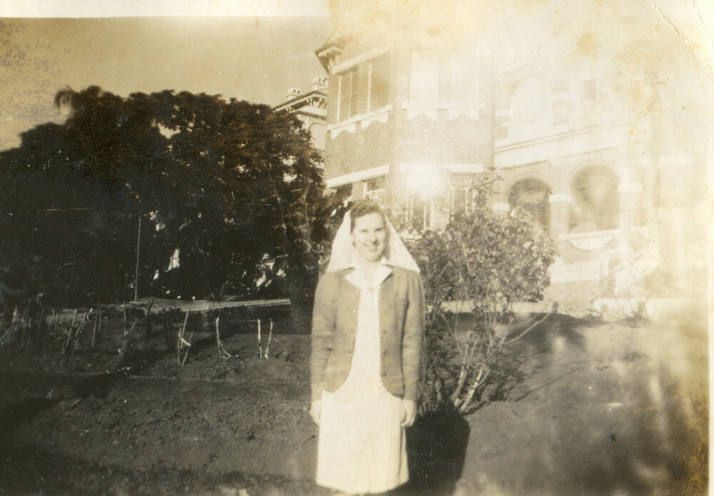 Nurse Aileen Cutler standing in front of Ipswich Hospital, Ipswich, 1940s
