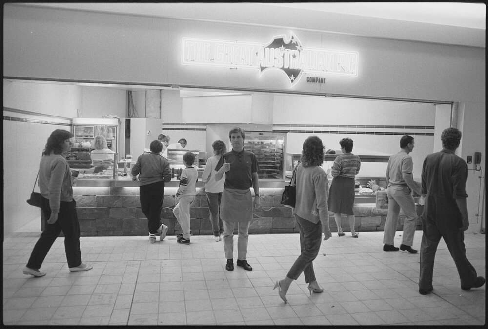 Unidentified people in front of the Redbank Plaza Shopping Centre The Great Australian Pie Company during the grand opening, Redbank, September 1985