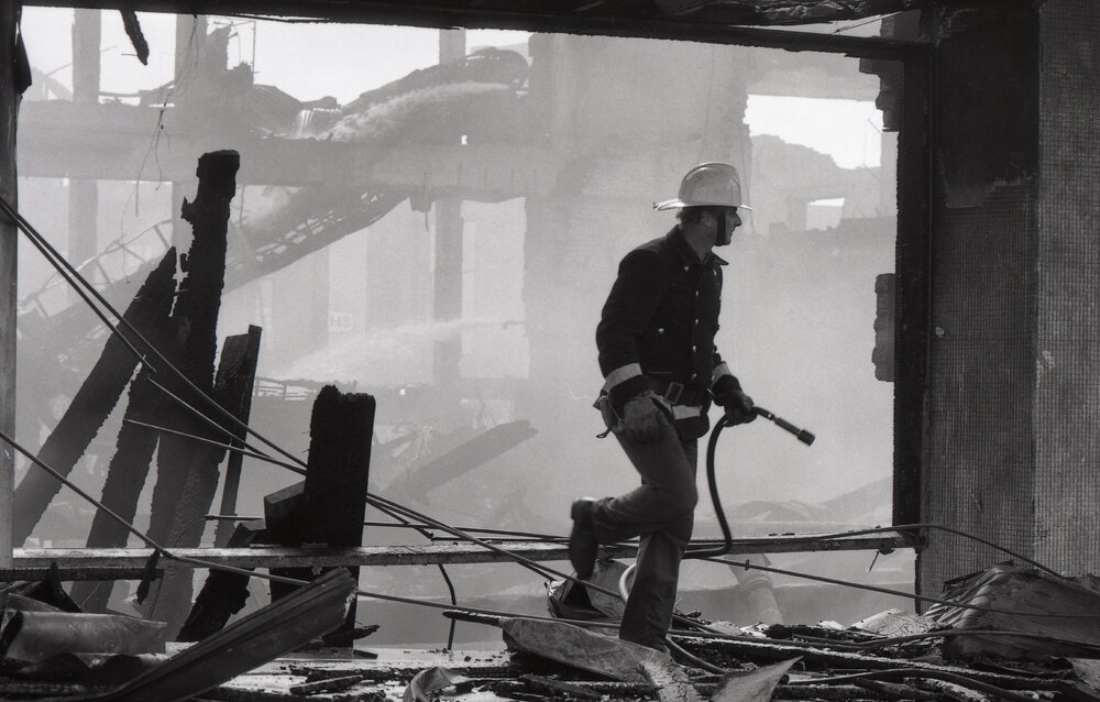 Firefighters walking though the remains of the Reid's store following the fire, Ipswich, August 1985