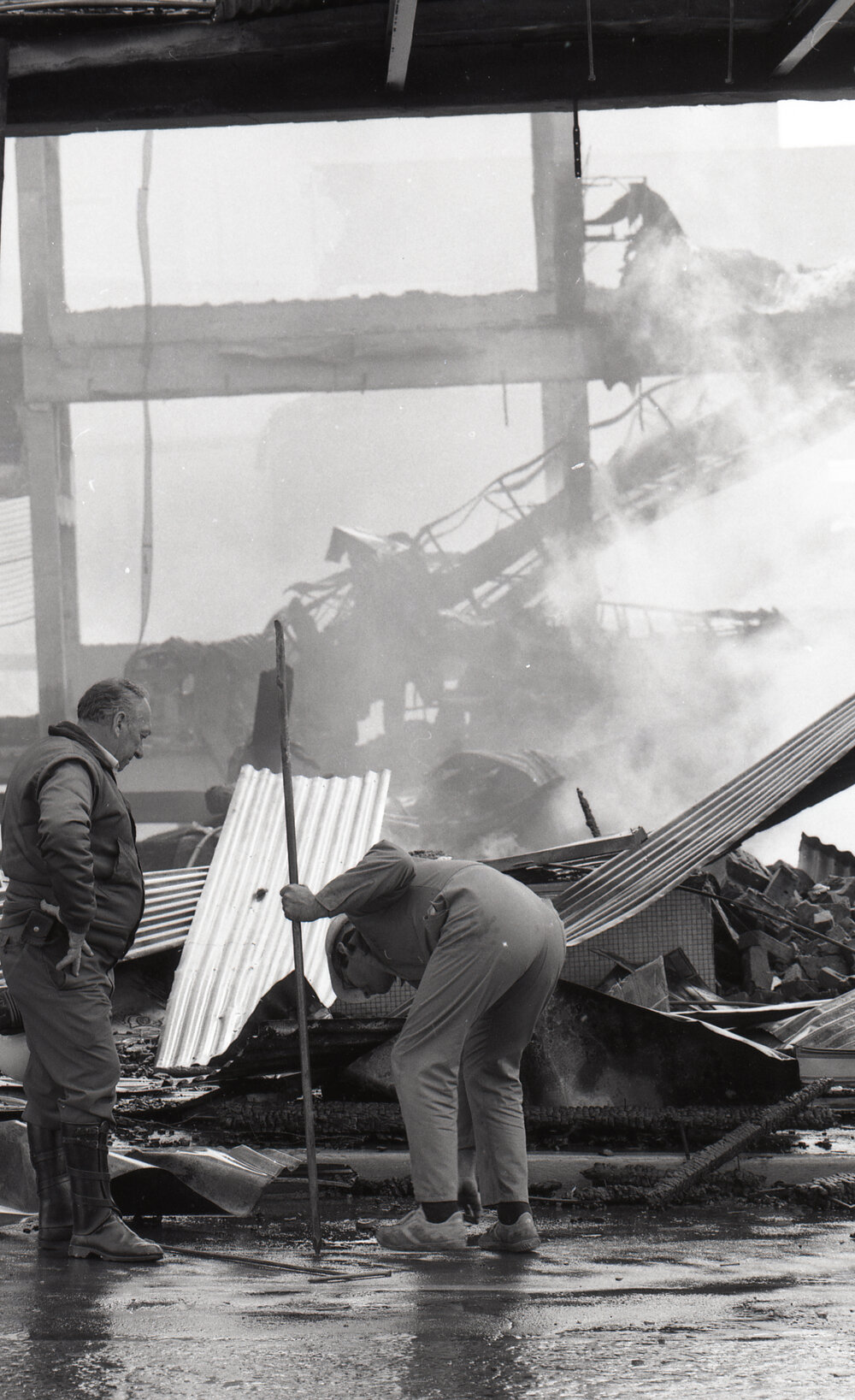 Police officers inspecting the aftermath of the Reid's (Cribb &amp; Foote) fire, Bell Street, Ipswich, August 1985