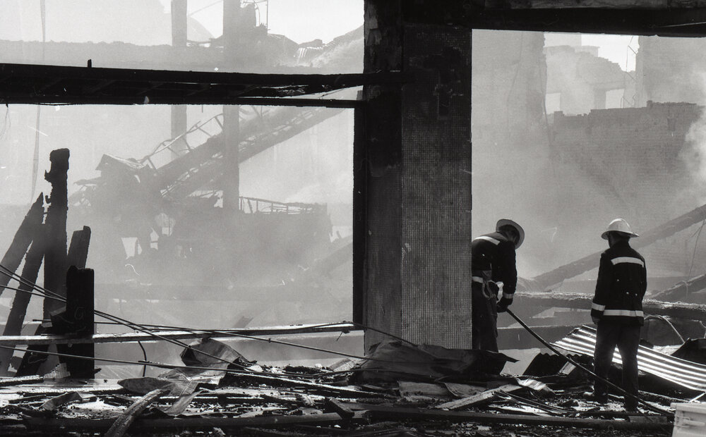 Firefighters walking though the remains of the Reid's store following the fire, Ipswich, August 1985