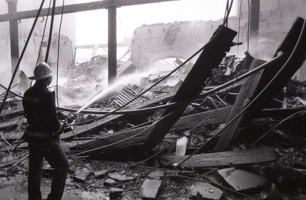 Firefighters walking though the remains of the Reid's store following the fire, Ipswich, August 1985