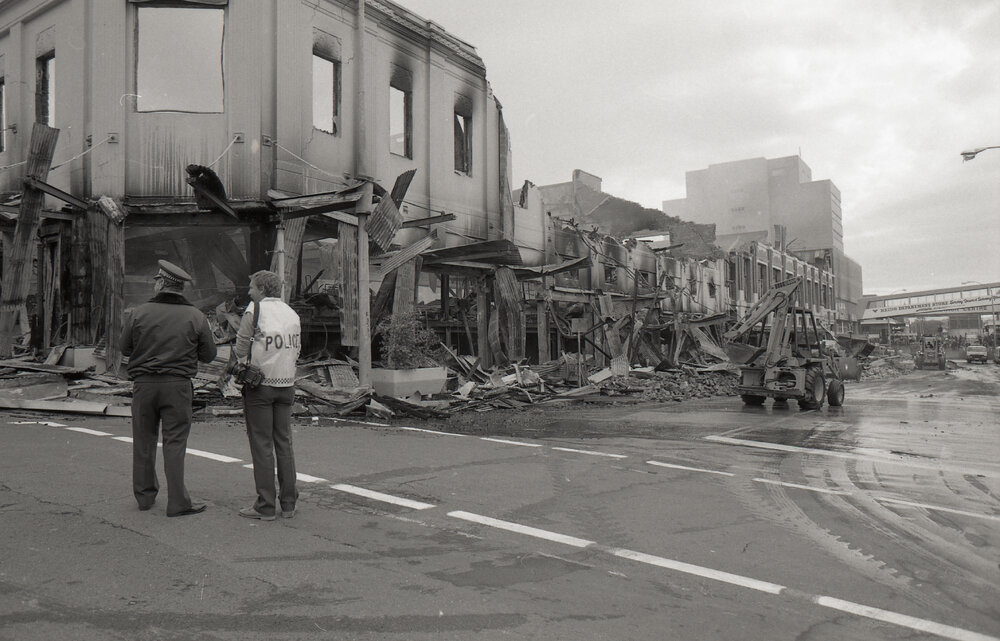 Police officers inspecting the aftermath of the Reid's (Cribb &amp; Foote) fire, Bell Street, Ipswich, August 1985