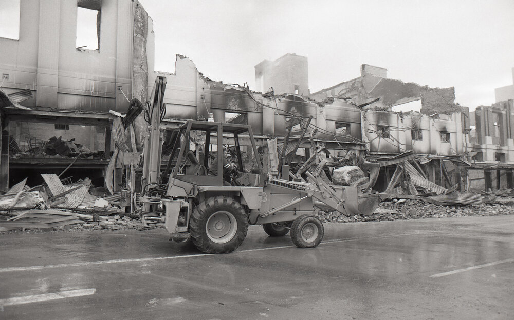 Bulldozer cleaning up the street of rubble, in the aftermath of the Reid's (Cribb &amp; Foote) fire, Bell Street, Ipswich, August 1985