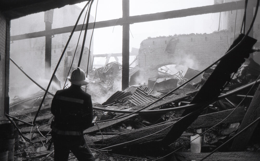 Firefighters hosing down the remains of the Reid's store following the fire, Ipswich, August 1985