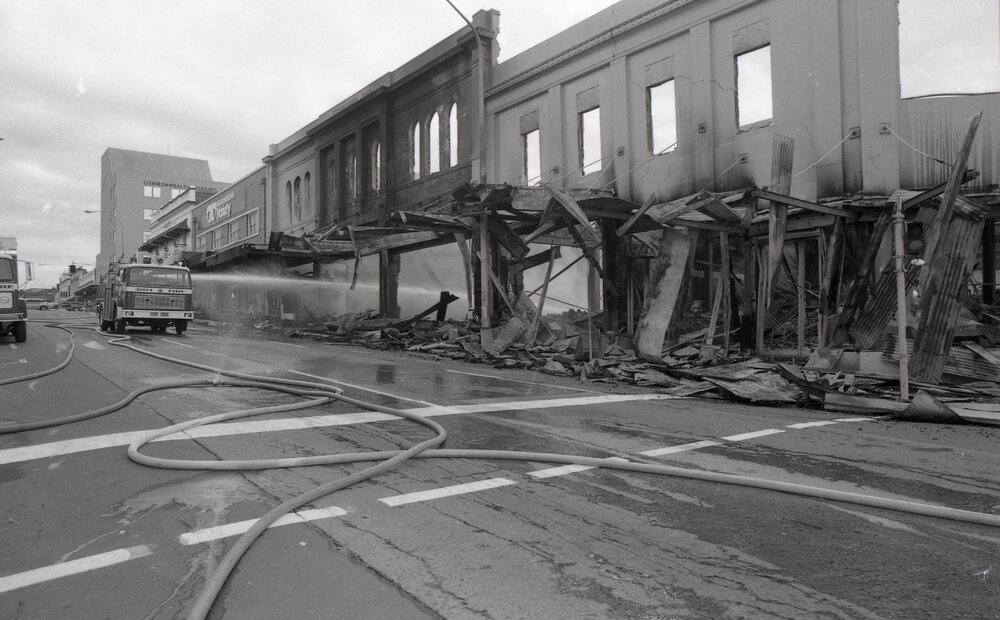 Firefighters hosing down the remains of the Reid's store following the fire, Ipswich, August 1985