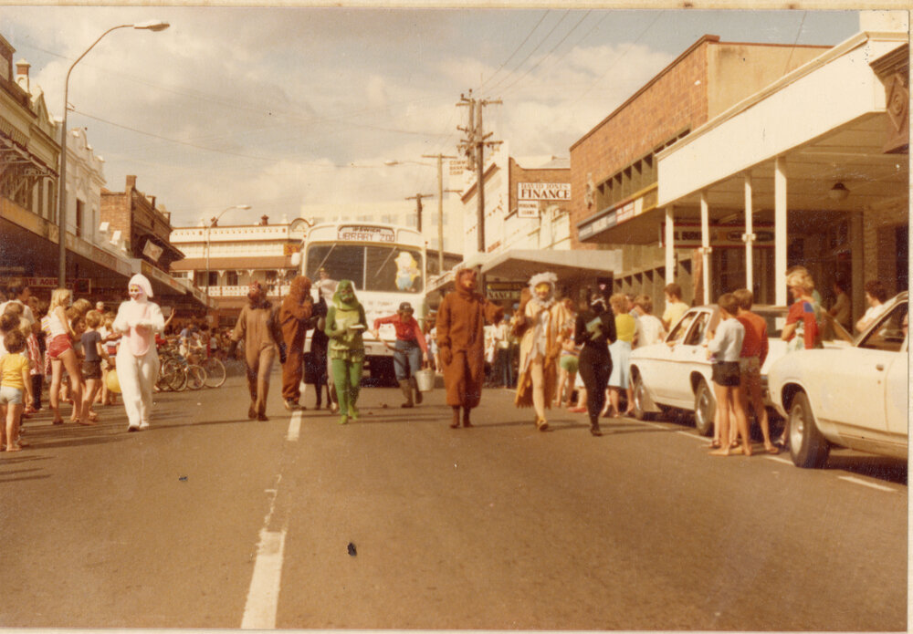 Library staff dressed as zoo animals with the Bookmobile in a parade, Brisbane Street, Ipswich, c.1980
