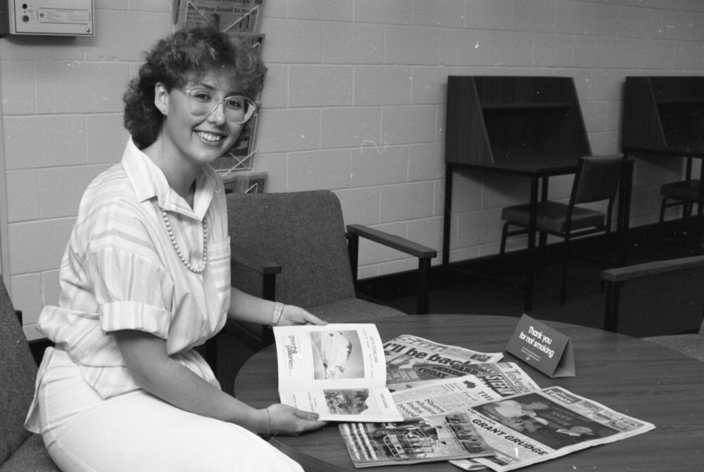 Unidentified library staff member with magazines at Redbank Plaza Library, Redbank, September 1985