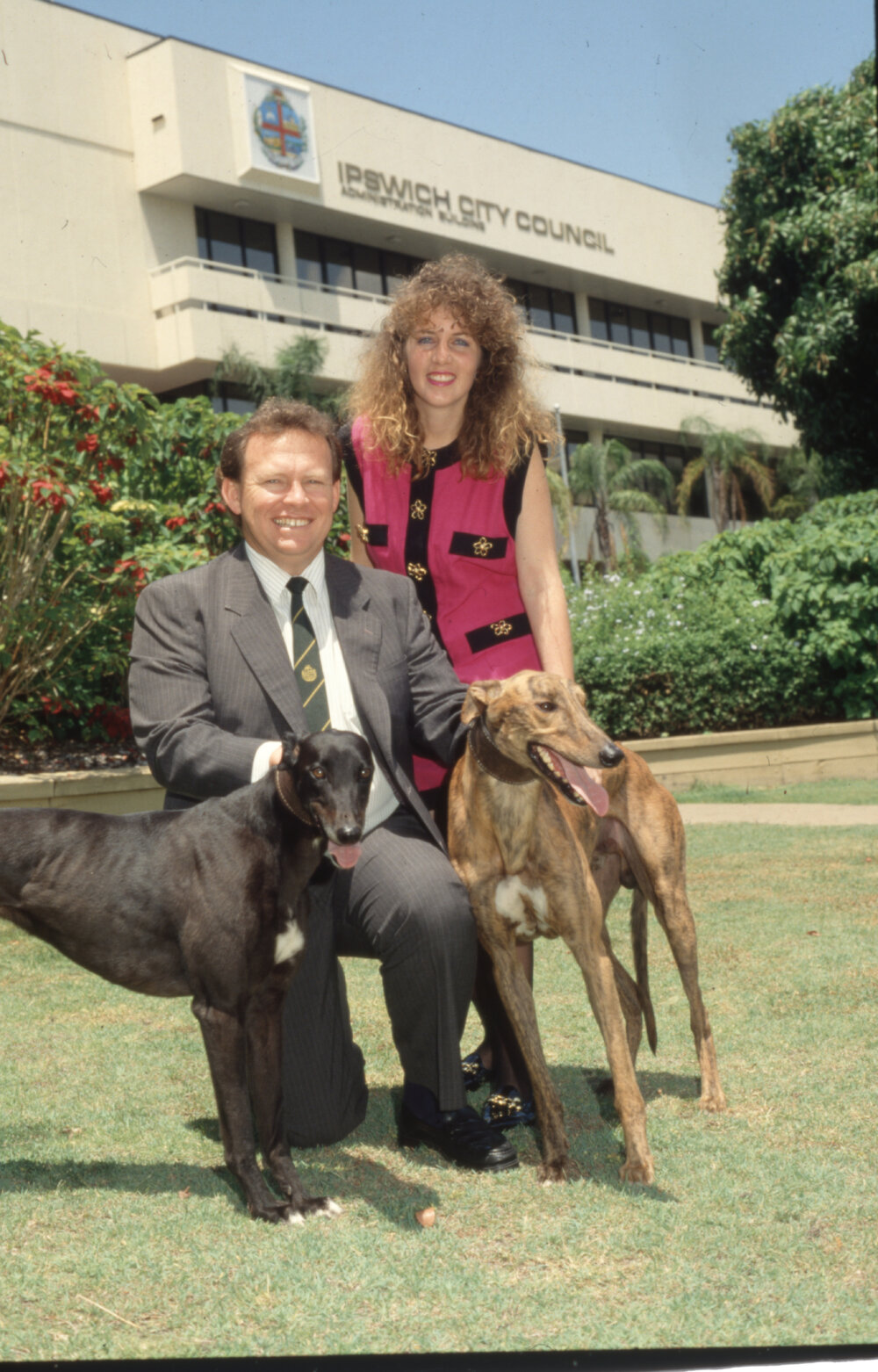 David Underwood, with unidentified lady and two greyhounds, in front of Council chambers, South Street, Ipswich, 1988