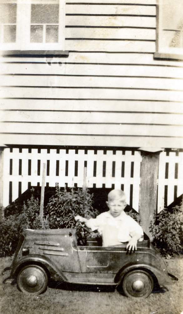 Child in toy car, Booval, Ipswich, 1944