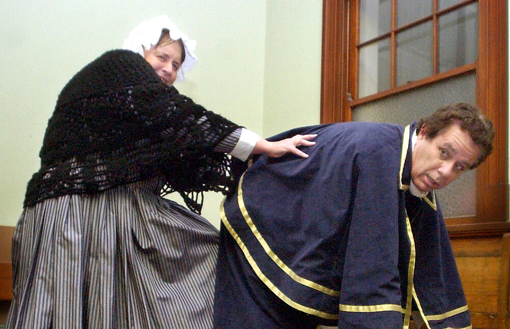 Rhonda Mitchell as "Widow Corney" kicking Jim Orr as "Mr Bumble" as part of the Oliver Musical cast, Ipswich, August 2004 